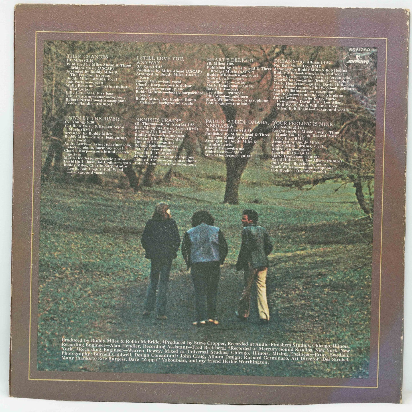 Album cover with three people in a park and text on a brown border