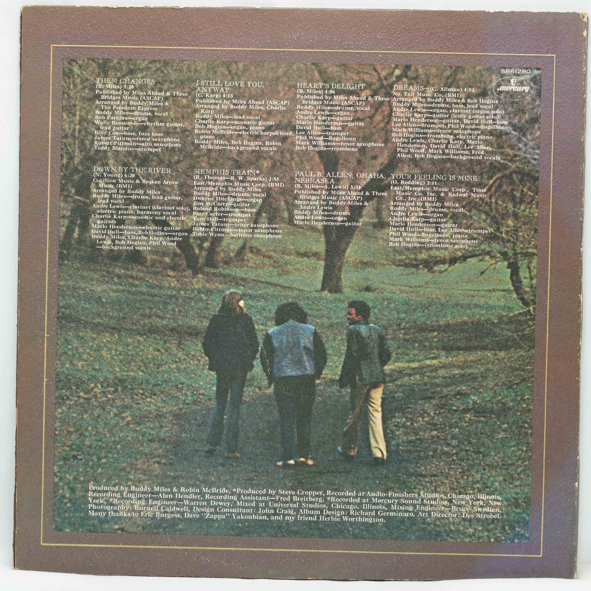 Album cover with three people in a park and text on a brown border